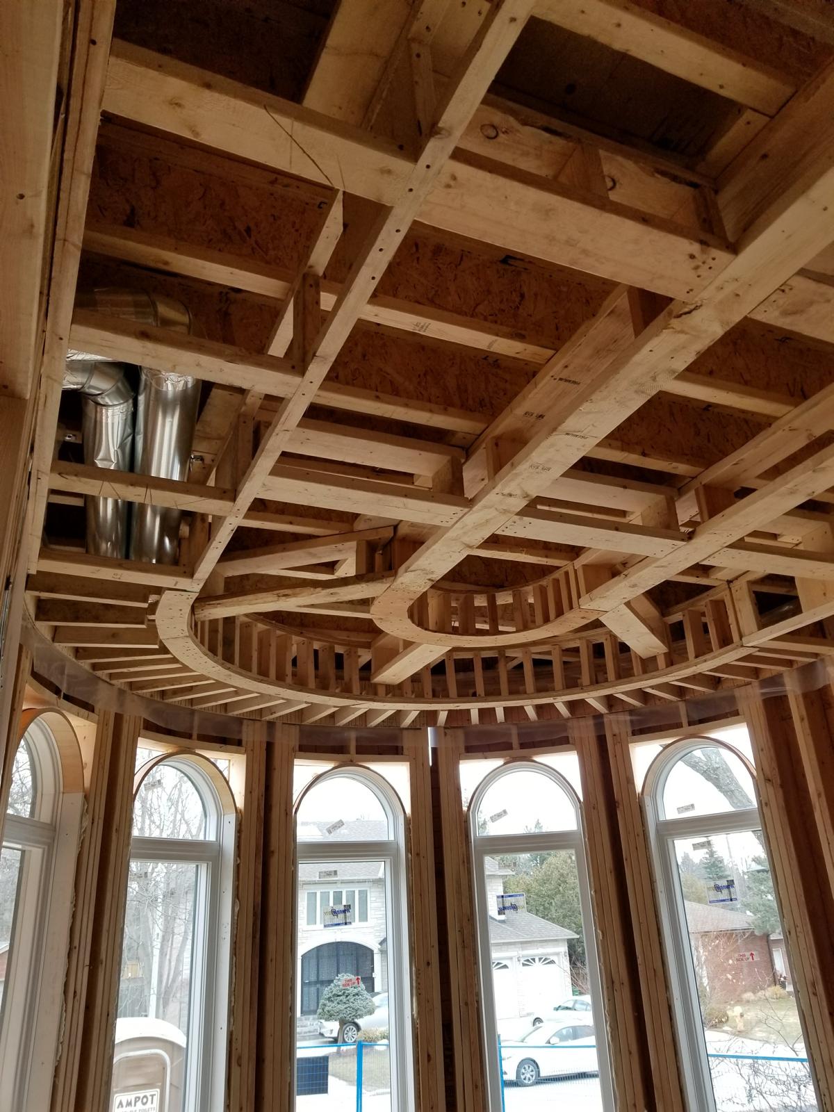Curved coffered ceiling framing above an arched window bay